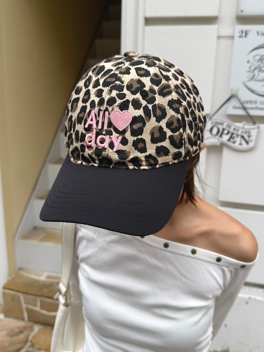 ホワイト系のTシャツ/カットソー、ブラウン系のデニムパンツ、ホワイト系のショルダーバッグを着用したレディースの秋コーディネートの2枚目の写真