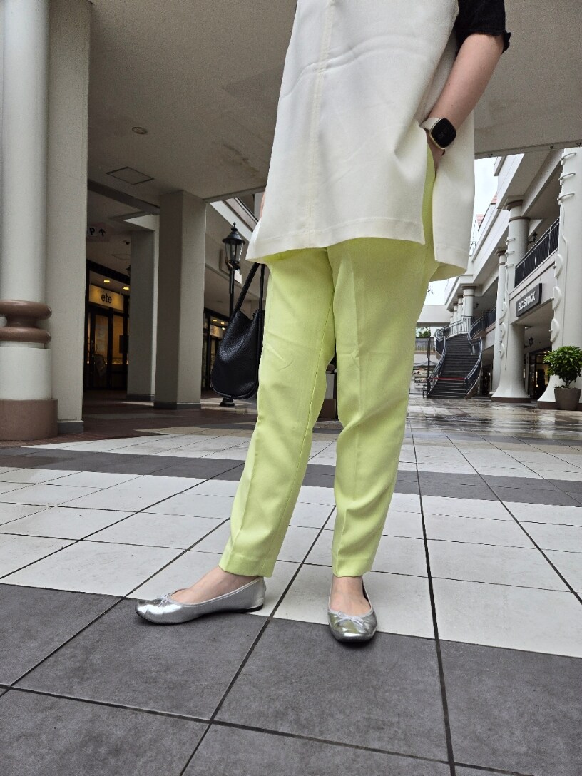 ブラック系のTシャツ/カットソー、ホワイト系のベスト、グリーン系のスラックスを着用したレディースの春コーディネートの3枚目の写真