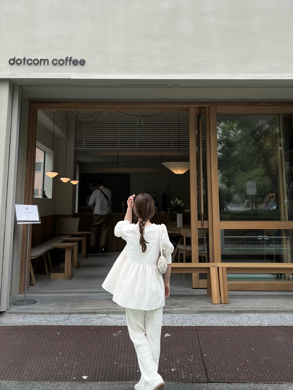 ホワイト系のパンツ、ホワイト系のトートバッグ、ホワイト系のスニーカーを着用したレディースの春コーディネートの3枚目の写真