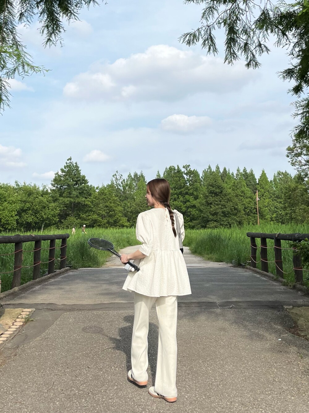 ホワイト系のパンツ、ホワイト系のトートバッグ、ホワイト系のスニーカーを着用したレディースの春コーディネートの2枚目の写真