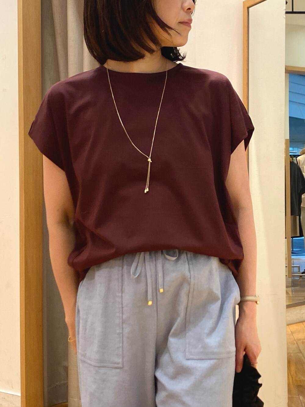 ブラウン系のTシャツ/カットソー、ブラック系のショルダーバッグ、ゴールド系のネックレスを着用したレディースの夏コーディネートの3枚目の写真