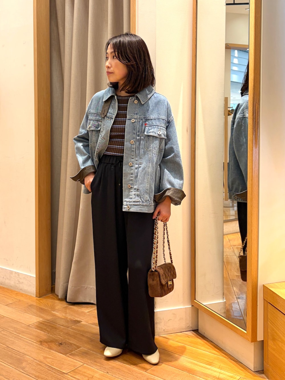 ブラック系のその他パンツ、ブルー系のデニムジャケット、ブラウン系のニット/セーターを着用したレディースの夏コーディネートの2枚目の写真