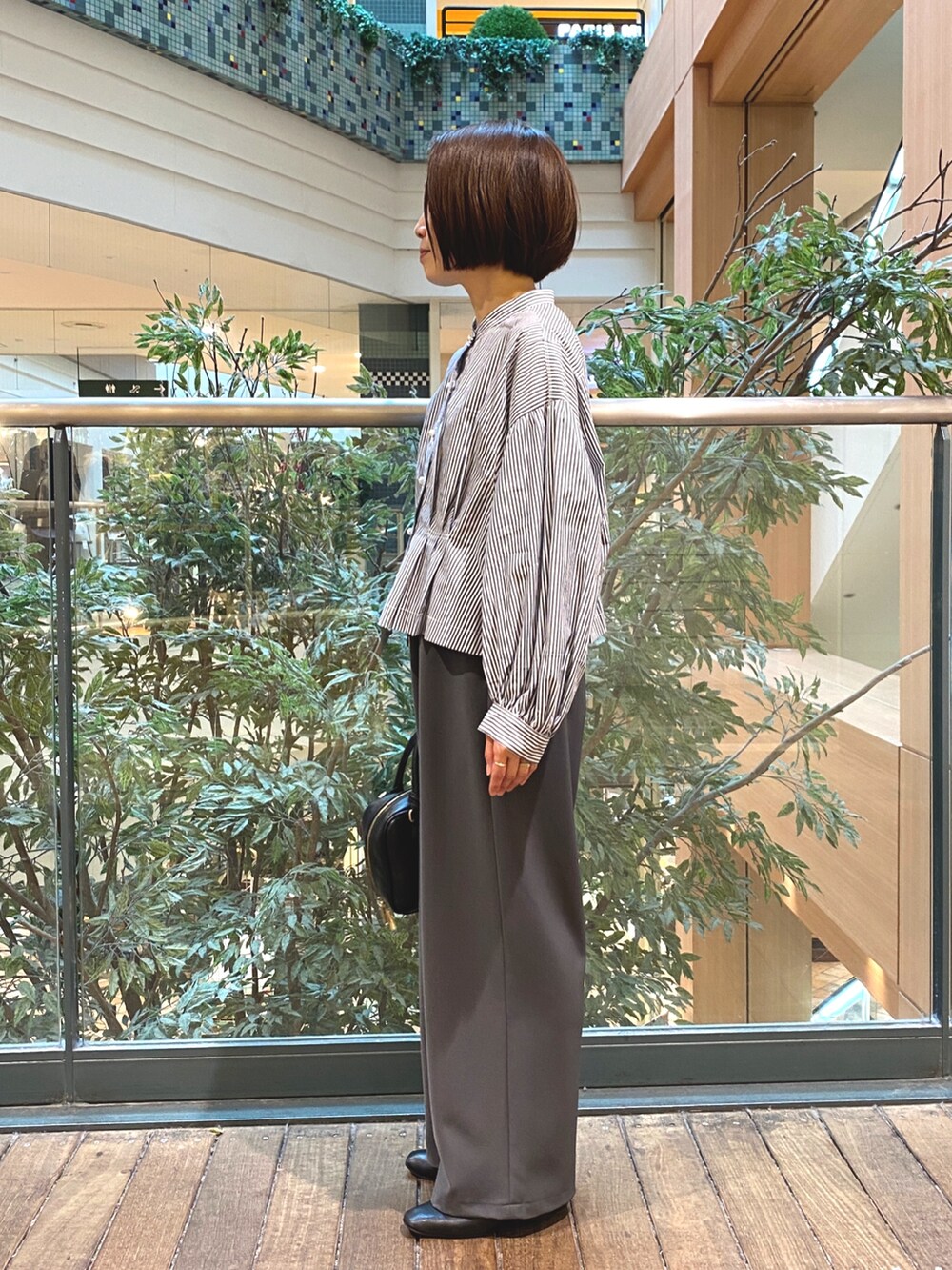 ブルー系のシャツ/ブラウス、ブラック系のハンドバッグ、グレー系のその他パンツを着用したレディースの秋コーディネートの4枚目の写真