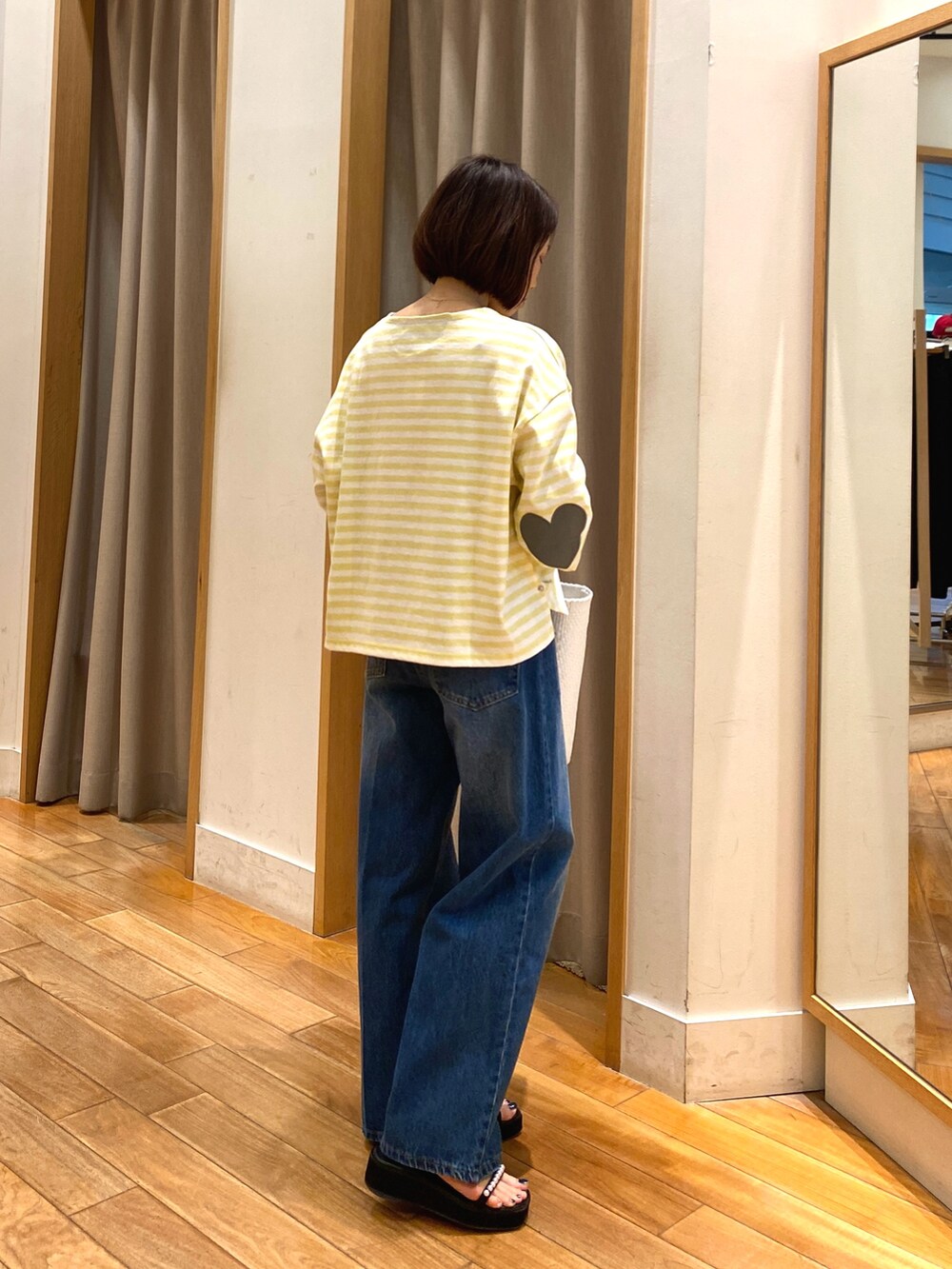 イエロー系のTシャツ/カットソー、ブルー系のデニムパンツ、ホワイト系のかごバッグを着用したレディースの春コーディネートの4枚目の写真