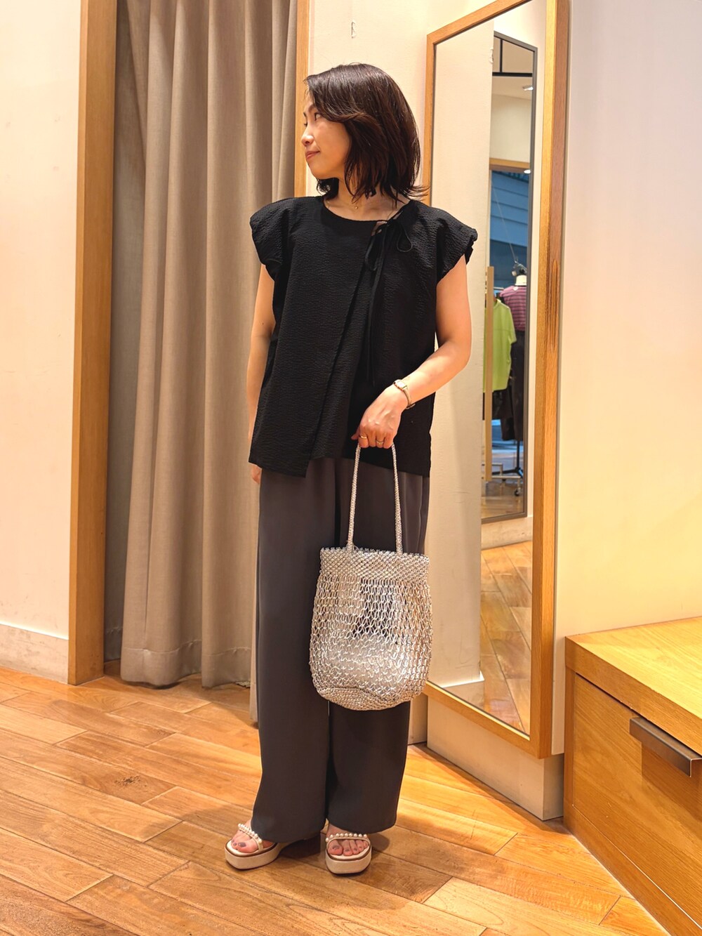 ブラック系のシャツ/ブラウス、グレー系のその他パンツ、シルバー系のかごバッグを着用したレディースの夏コーディネートの4枚目の写真