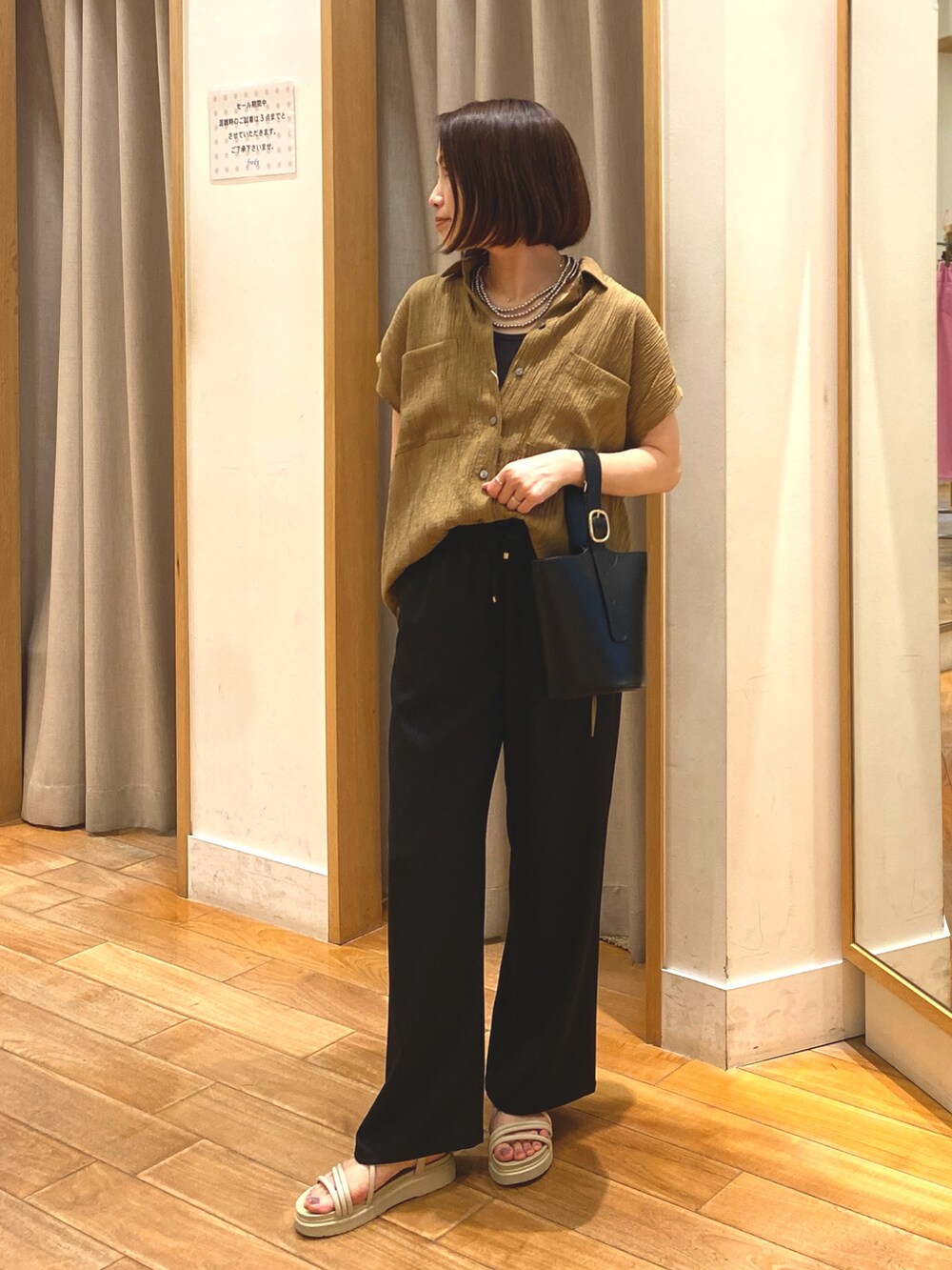 ブラック系のその他パンツ、イエロー系のシャツ/ブラウス、ブラック系のショルダーバッグを着用したレディースの夏コーディネートの3枚目の写真