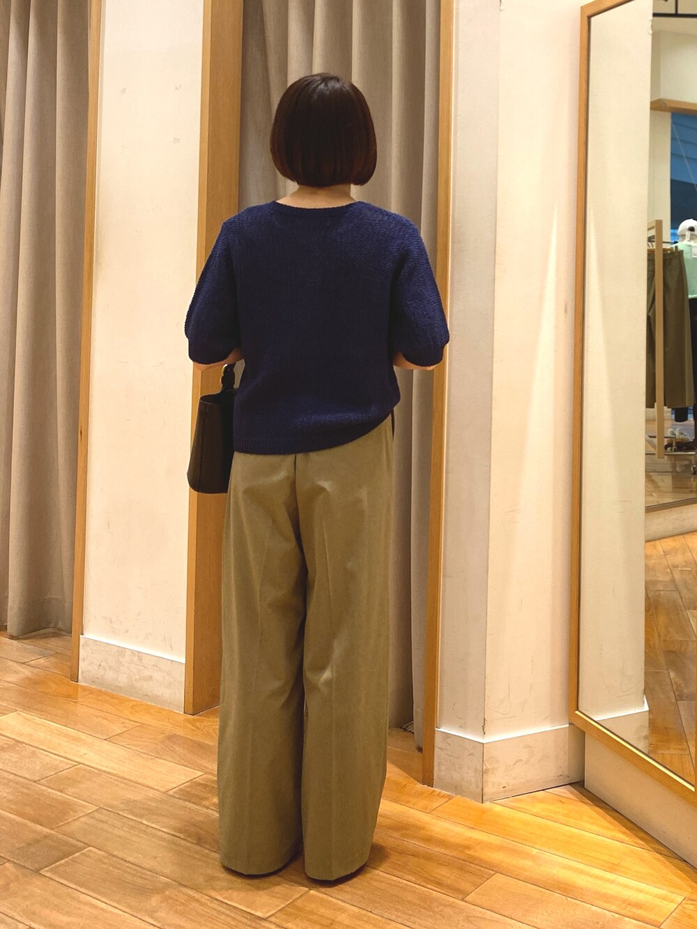ブルー系のカーディガン/ボレロ、ホワイト系のTシャツ/カットソー、イエロー系のスラックスを着用したレディースの春コーディネートの7枚目の写真