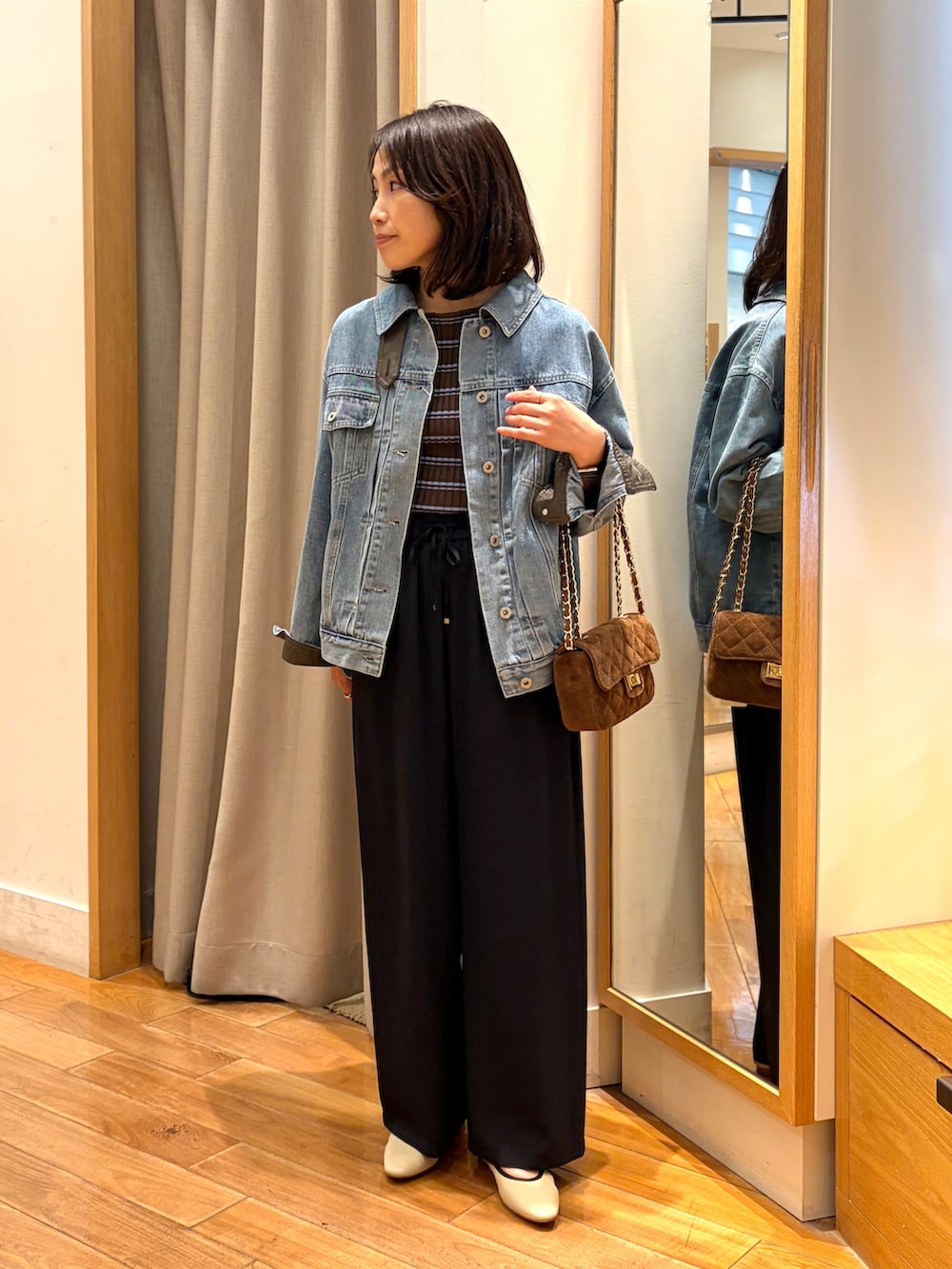ブラック系のその他パンツ、ブルー系のデニムジャケット、ブラウン系のニット/セーターを着用したレディースの夏コーディネートの4枚目の写真
