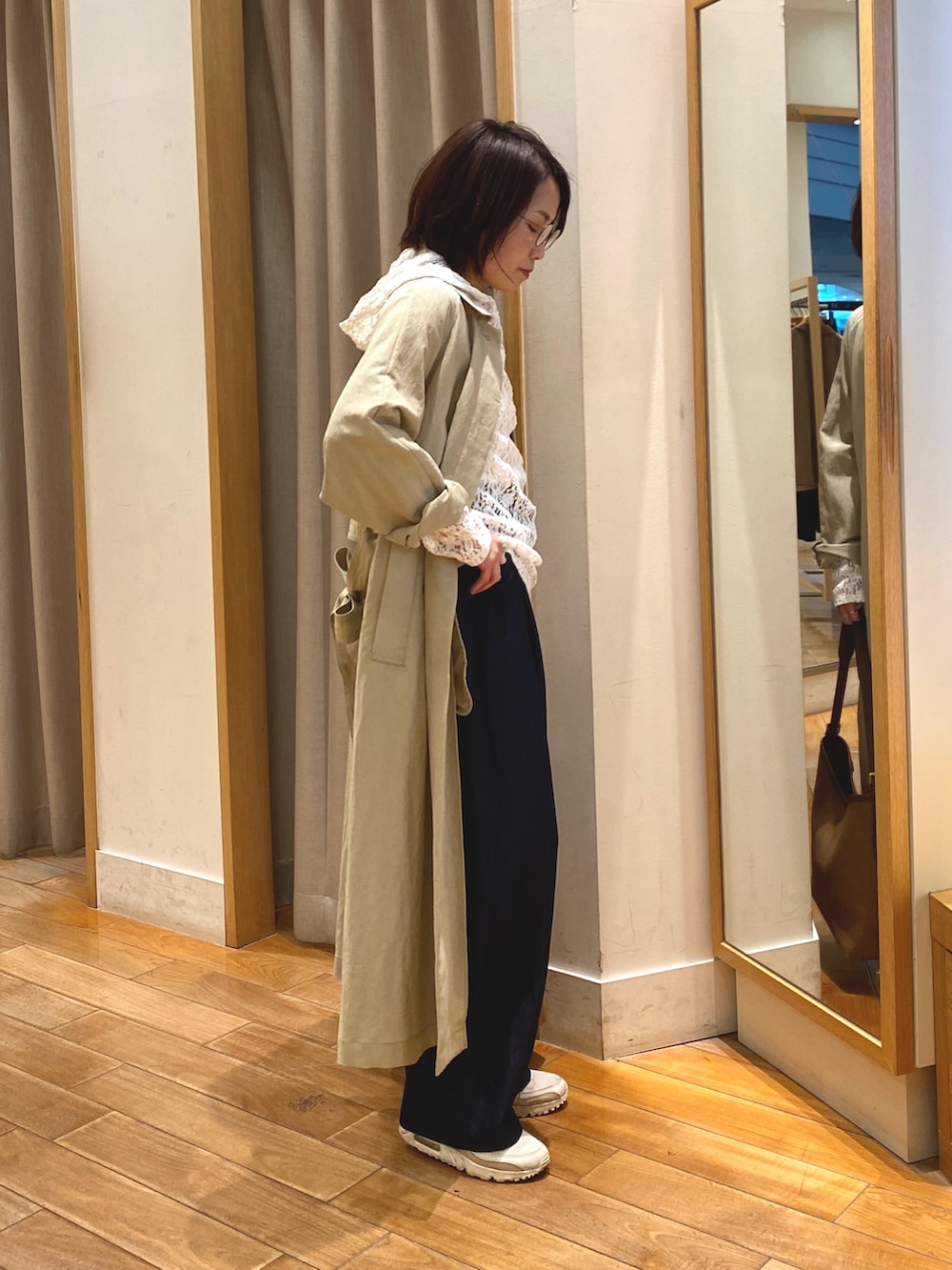 ホワイト系のTシャツ/カットソー、ベージュ系のステンカラーコート、ブラウン系のショルダーバッグを着用したレディースの春コーディネートの6枚目の写真