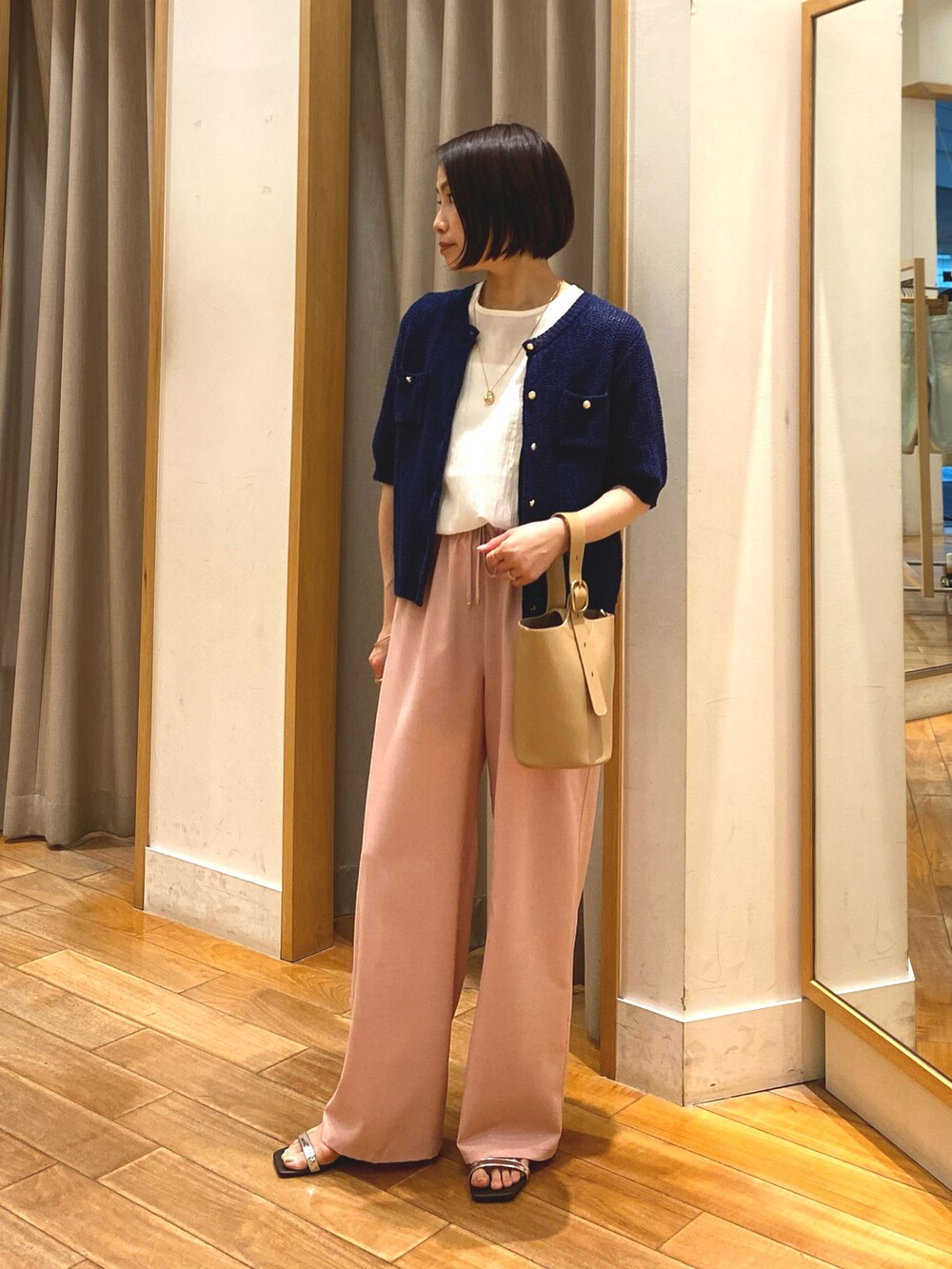 ピンク系のその他パンツ、ベージュ系のショルダーバッグ、ブルー系のカーディガン/ボレロを着用したレディースの春コーディネートの2枚目の写真