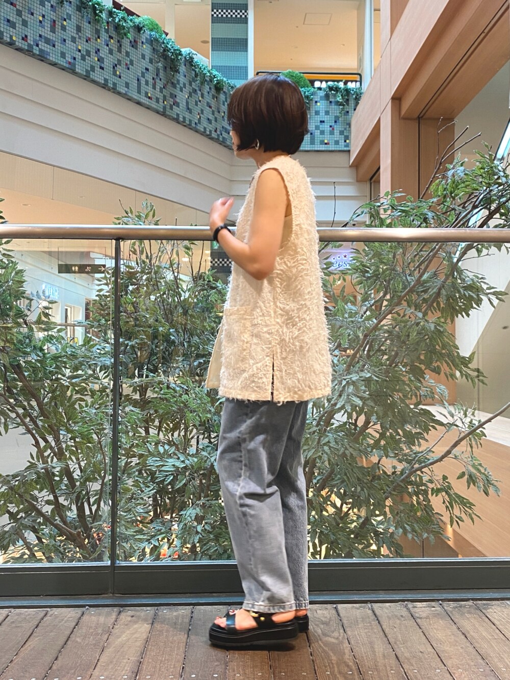 ホワイト系のベスト、ホワイト系のTシャツ/カットソー、ブルー系のデニムパンツを着用したレディースの夏コーディネートの3枚目の写真