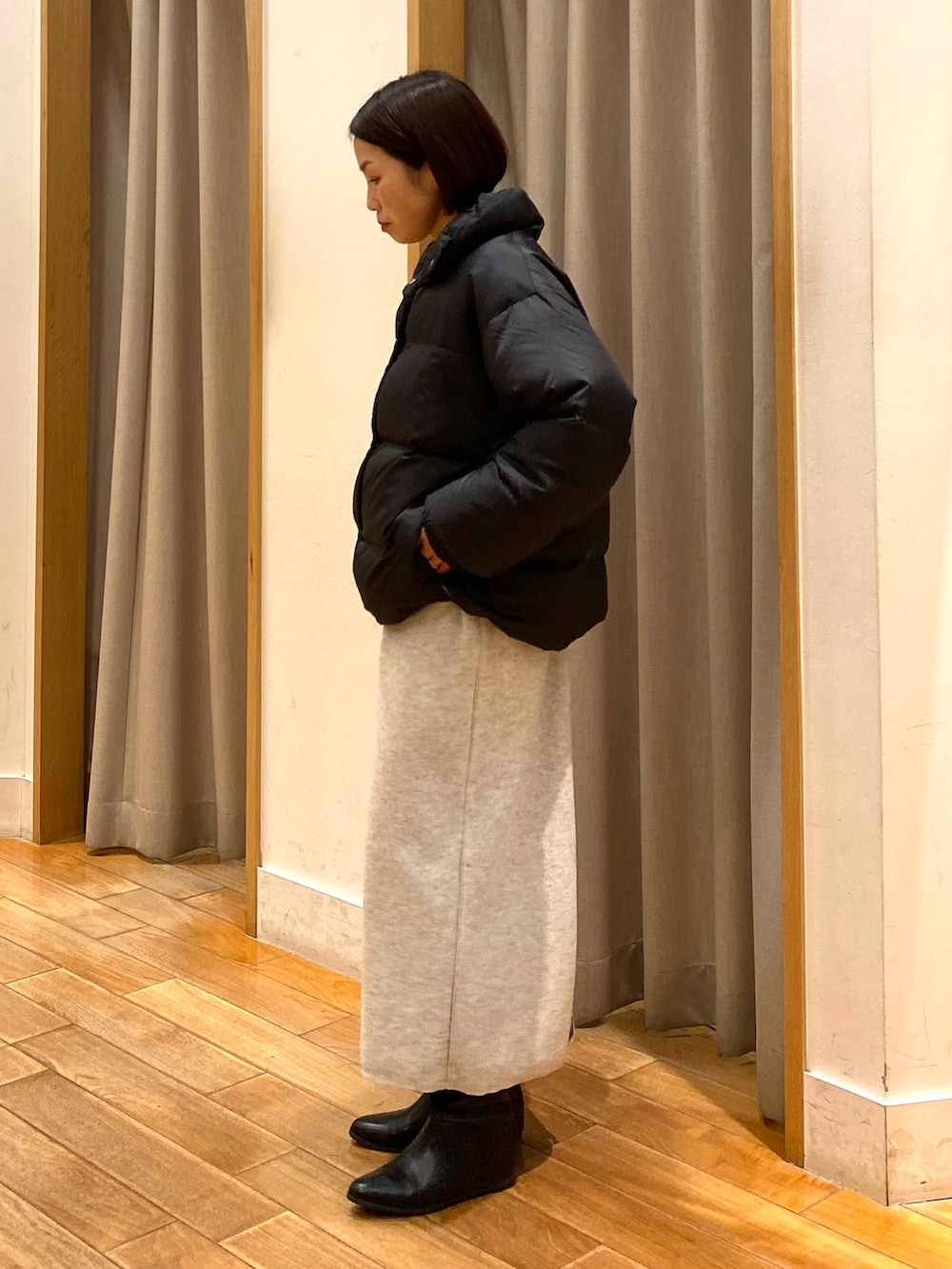 ベージュ系のショルダーバッグ、ブラック系のダウンジャケット/コート、ホワイト系のTシャツ/カットソーを着用したレディースの秋コーディネートの5枚目の写真