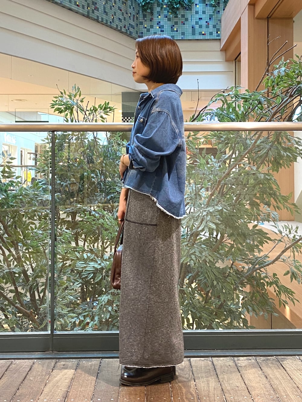 ブルー系のシャツ/ブラウス、グレー系のスカート、ホワイト系のTシャツ/カットソーを着用したレディースの秋コーディネートの4枚目の写真