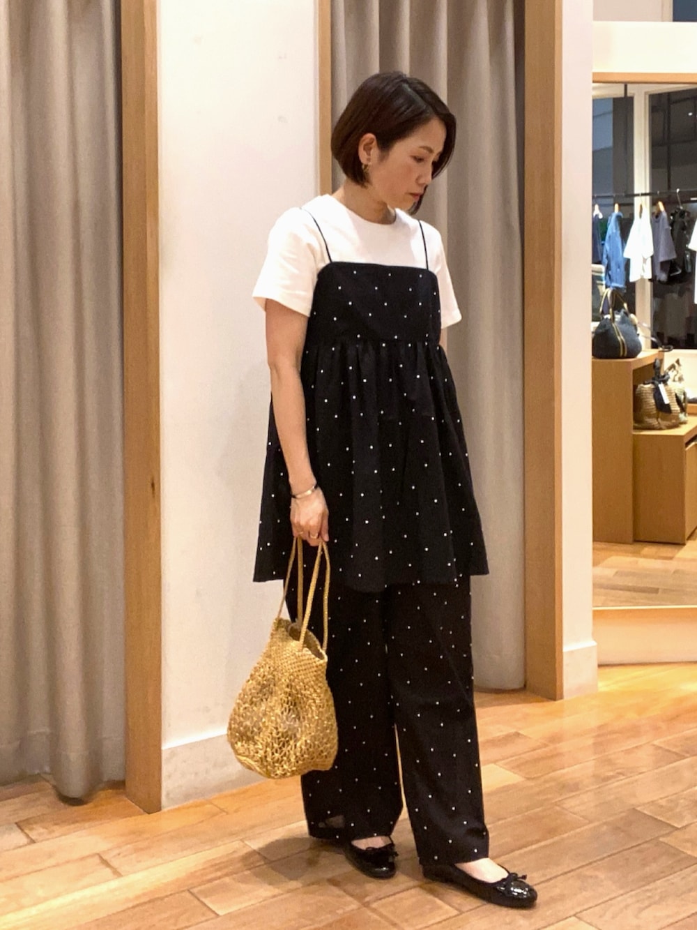 ホワイト系のTシャツ/カットソー、ブラック系のキャミソール、ゴールド系のショルダーバッグを着用したレディースの夏コーディネートの4枚目の写真