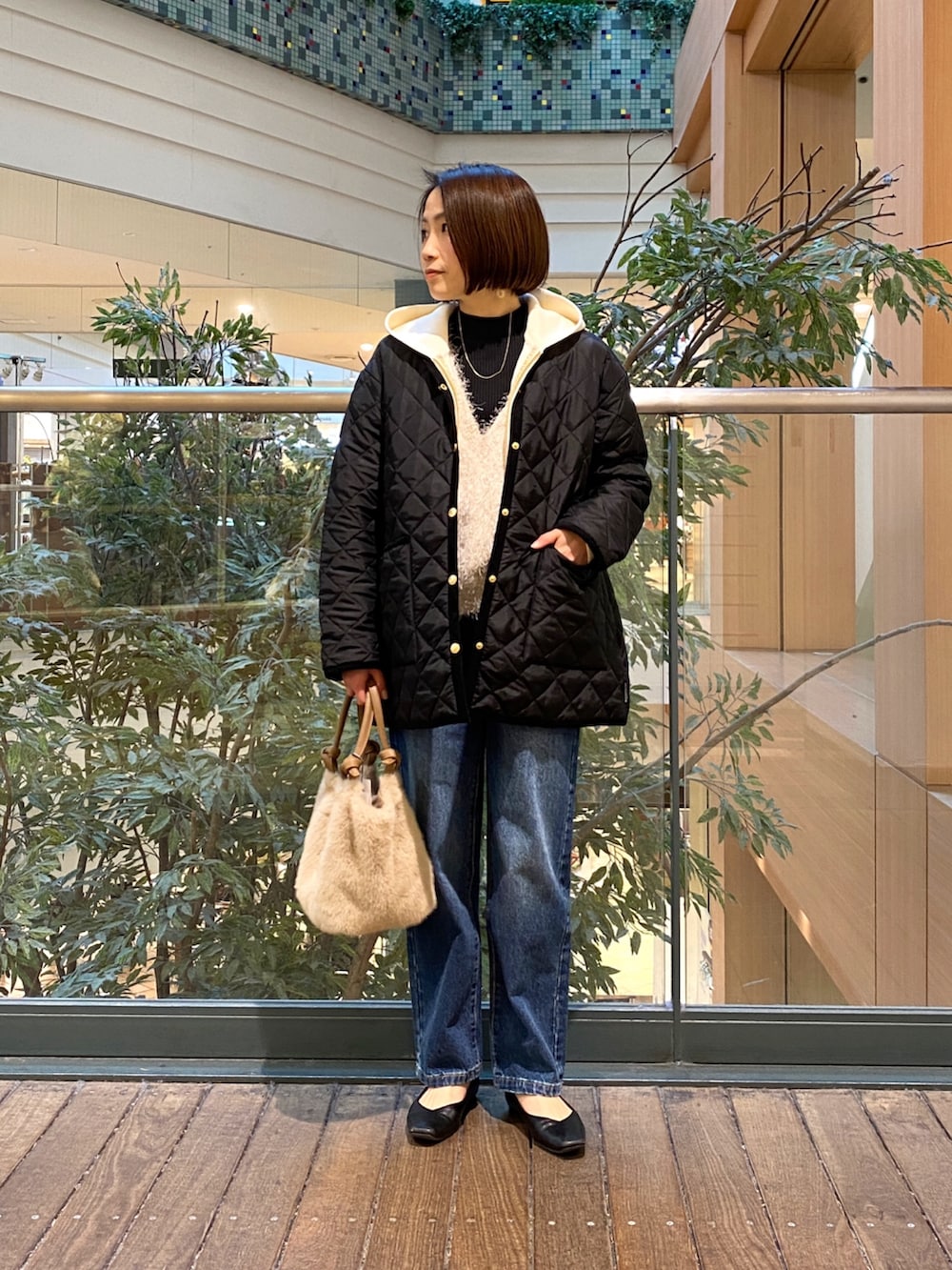 ホワイト系のスウェット、ブラック系のブルゾン、ブラック系のその他トップスを着用したレディースの冬コーディネートの2枚目の写真