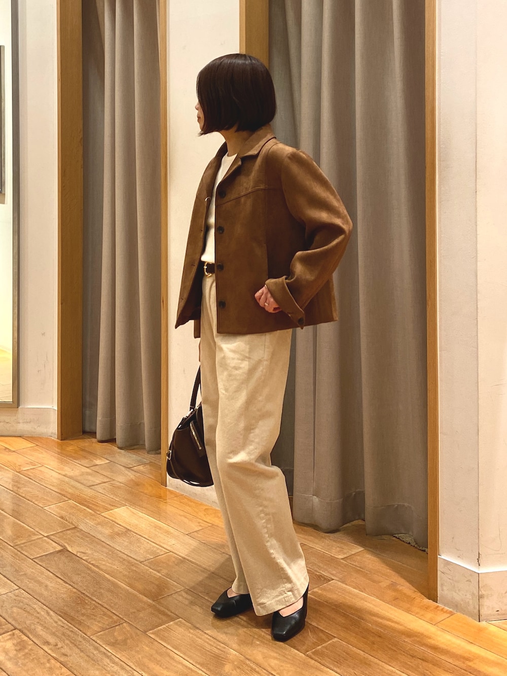 ブラウン系のダウンジャケット/コート、ホワイト系のニット/セーター、ブラウン系のショルダーバッグを着用したレディースの秋コーディネートの3枚目の写真