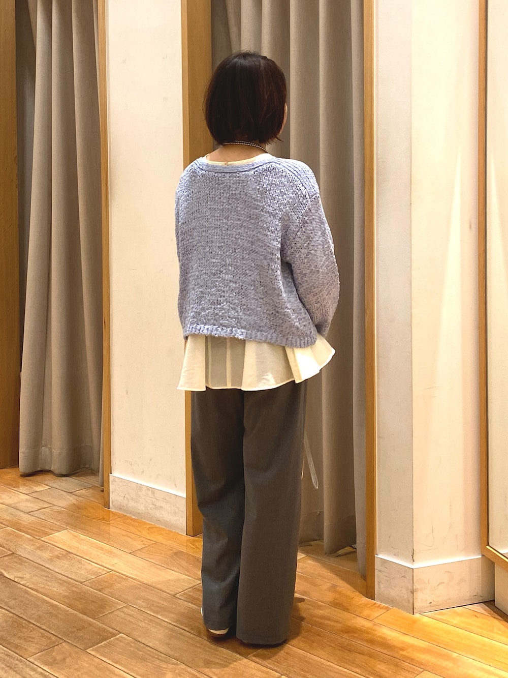 グレー系のその他パンツ、ホワイト系のシャツ/ブラウス、ブルー系のニット/セーターを着用したレディースの春コーディネートの6枚目の写真