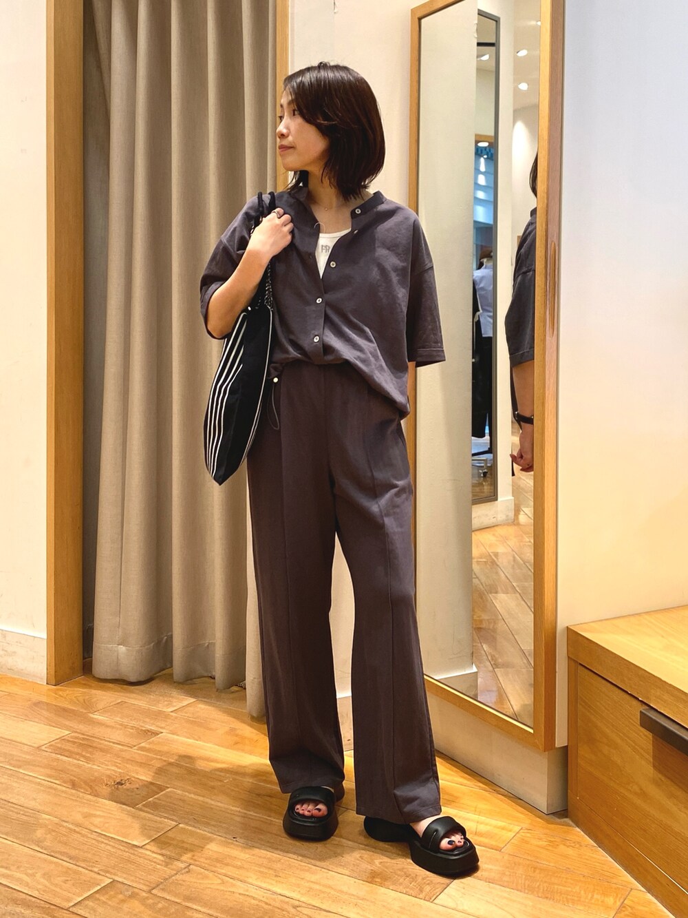 グレー系のその他パンツ、ホワイト系のトートバッグ、グレー系のシャツ/ブラウスを着用したレディースの夏コーディネートの4枚目の写真