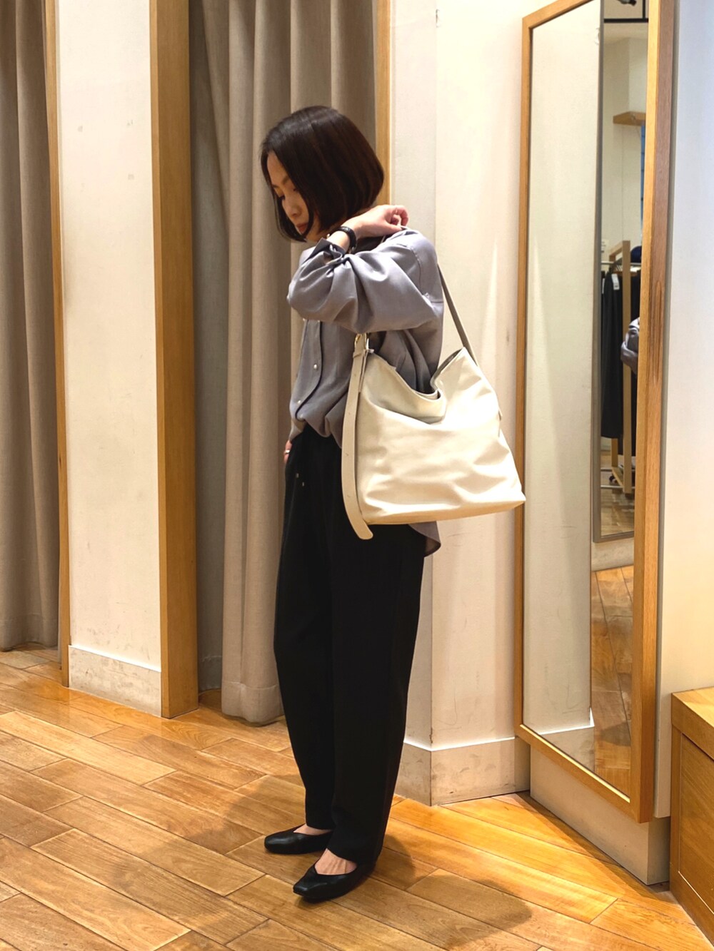 ブラック系のタンクトップ、ブラック系のその他パンツ、ホワイト系のショルダーバッグを着用したレディースの春コーディネートの2枚目の写真