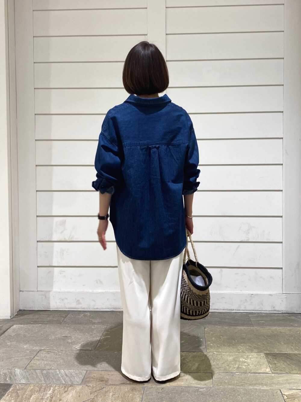 ブルー系のシャツ/ブラウス、ブラック系のかごバッグ、ホワイト系のその他パンツを着用したレディースの春コーディネートの6枚目の写真