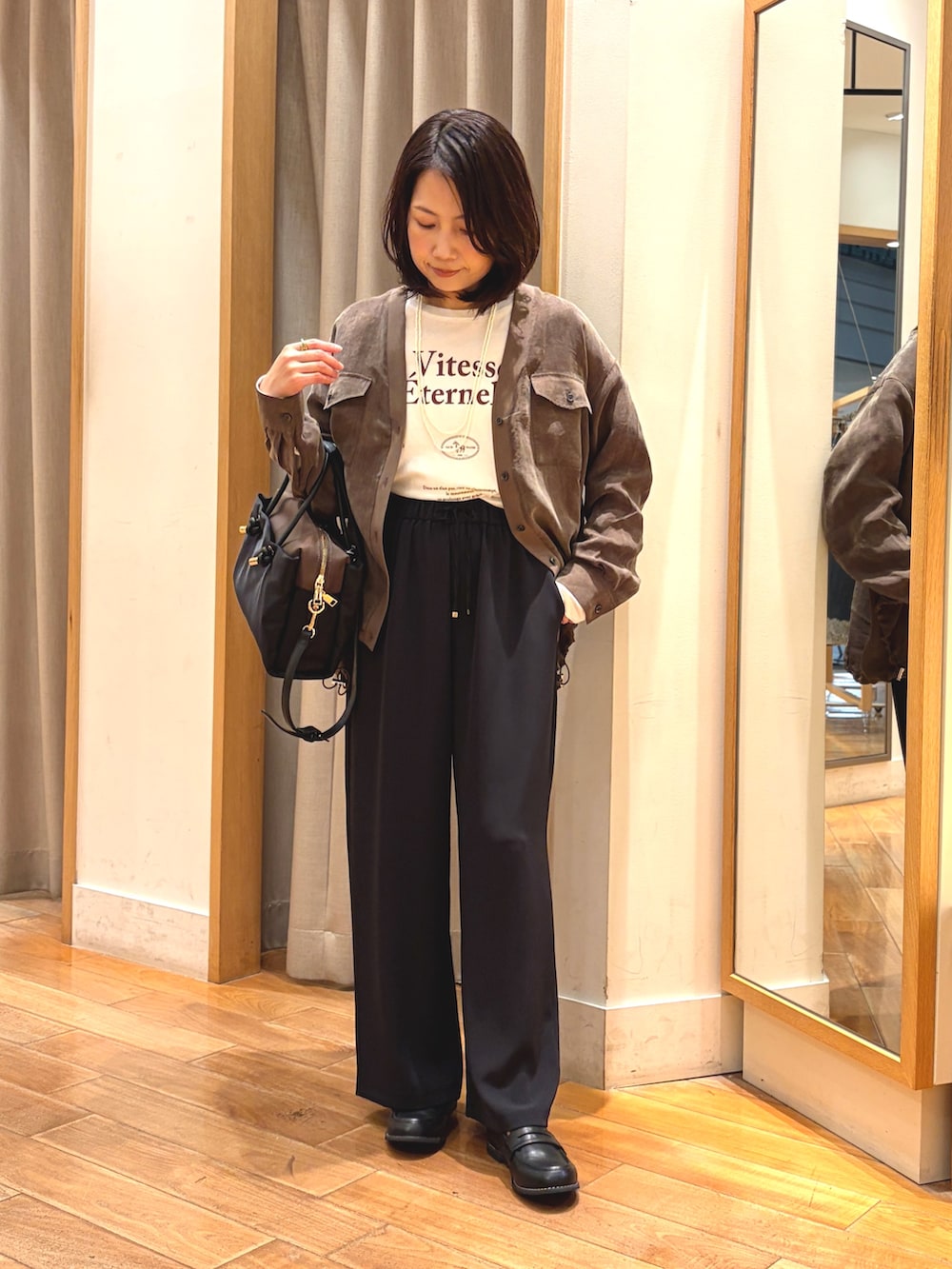 ブラック系のその他パンツ、ホワイト系のTシャツ/カットソー、ブラック系のボストンバッグを着用したレディースの秋コーディネートの4枚目の写真