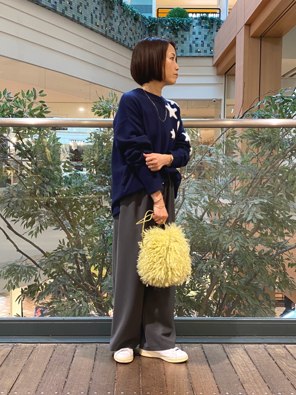 ブルー系のニット/セーター、グレー系のその他パンツ、イエロー系のショルダーバッグを着用したレディースの秋コーディネートの2枚目の写真