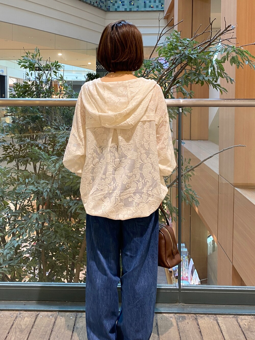 ホワイト系のシャツ/ブラウス、ブルー系のデニムパンツ、ブラウン系のボストンバッグを着用したレディースの秋コーディネートの5枚目の写真