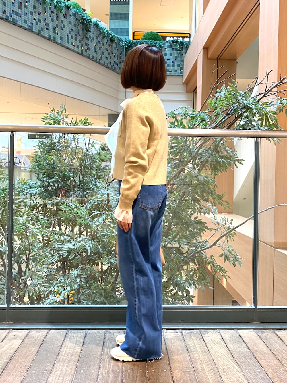 ホワイト系のシャツ/ブラウス、ベージュ系のカーディガン/ボレロ、ブルー系のデニムパンツを着用したレディースの冬コーディネートの3枚目の写真