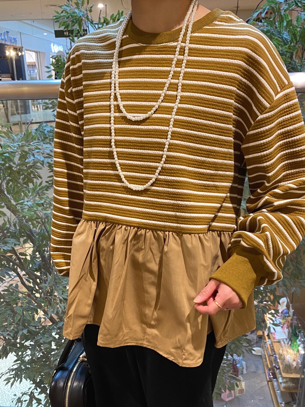 ベージュ系のTシャツ/カットソー、ブラック系のハンドバッグ、ブラック系のその他パンツを着用したレディースの冬コーディネートの5枚目の写真