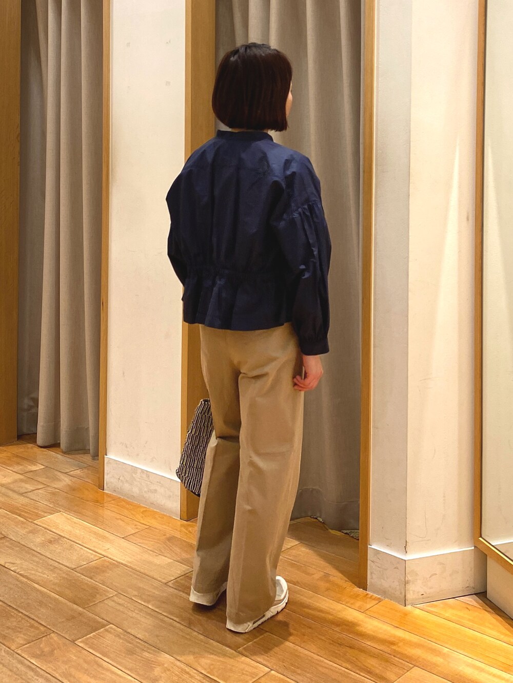 ベージュ系のチノパンツ、ブルー系のシャツ/ブラウス、ホワイト系のTシャツ/カットソーを着用したレディースの春コーディネートの4枚目の写真