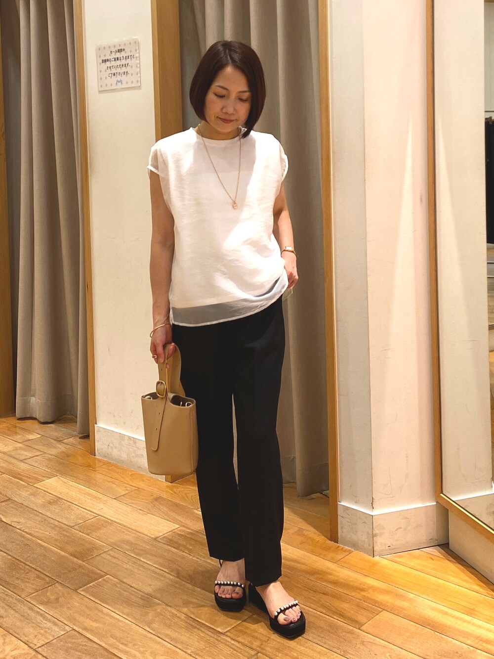 ブラック系のその他パンツ、ホワイト系のシャツ/ブラウス、ベージュ系のショルダーバッグを着用したレディースの夏コーディネートの2枚目の写真