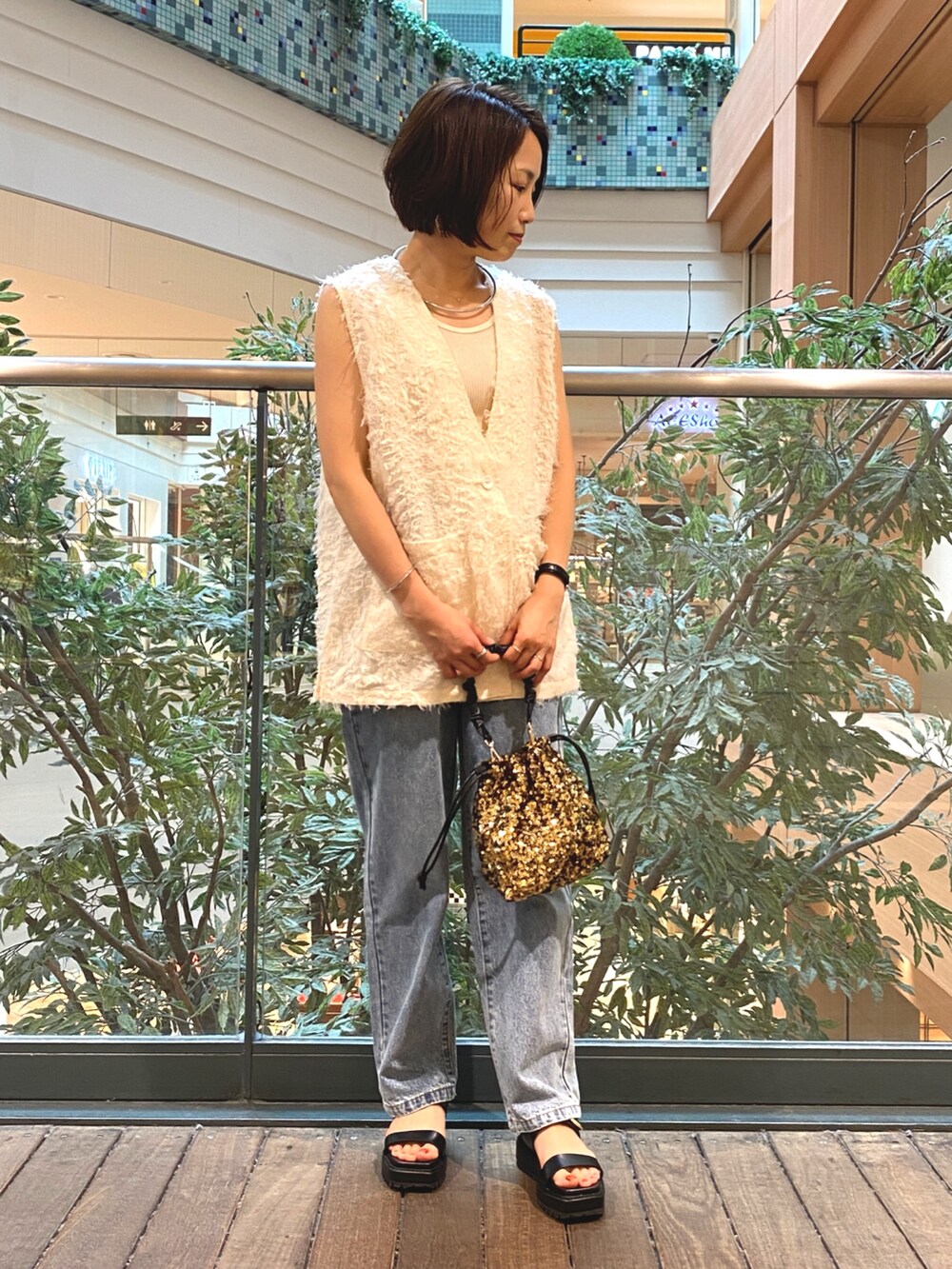 ホワイト系のベスト、ホワイト系のTシャツ/カットソー、ブルー系のデニムパンツを着用したレディースの夏コーディネートの2枚目の写真