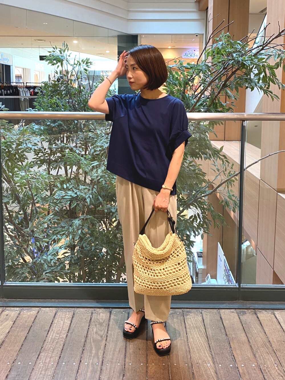 ブルー系のTシャツ/カットソー、ベージュ系のかごバッグ、ベージュ系のその他パンツを着用したレディースの夏コーディネートの2枚目の写真