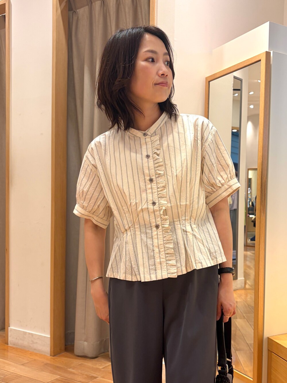 グレー系のその他パンツ、ホワイト系のシャツ/ブラウス、ブラック系のショルダーバッグを着用したレディースの夏コーディネートの3枚目の写真