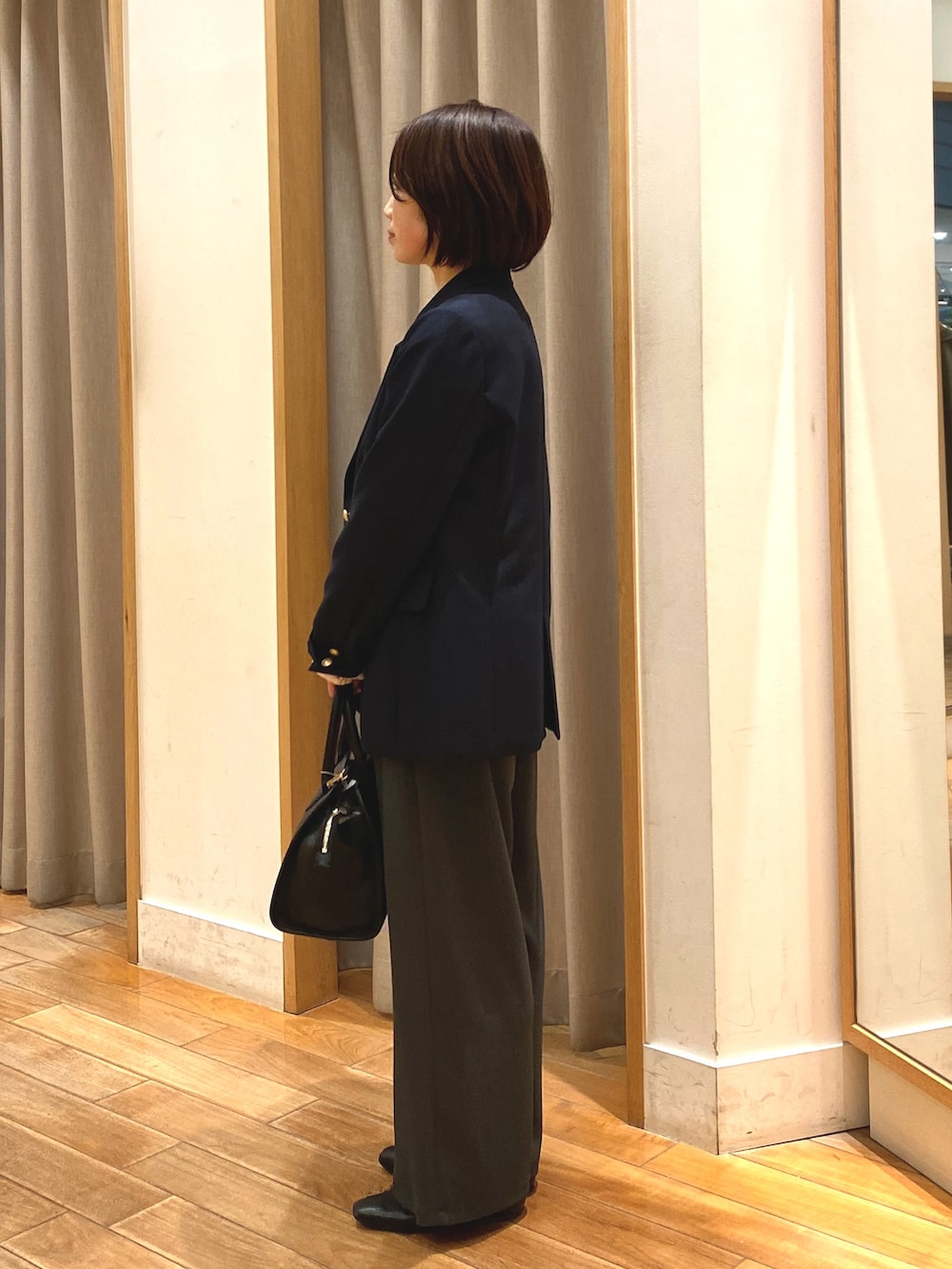 グレー系のその他パンツ、ブラック系のショルダーバッグ、ホワイト系のシャツ/ブラウスを着用したレディースの春コーディネートの6枚目の写真