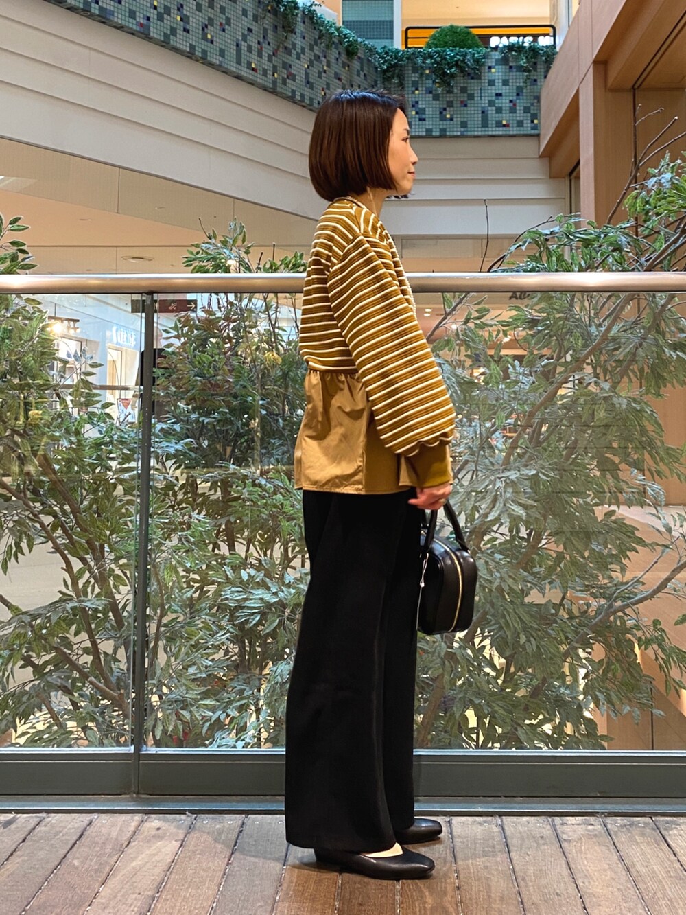 ベージュ系のTシャツ/カットソー、ブラック系のハンドバッグ、ブラック系のその他パンツを着用したレディースの冬コーディネートの4枚目の写真