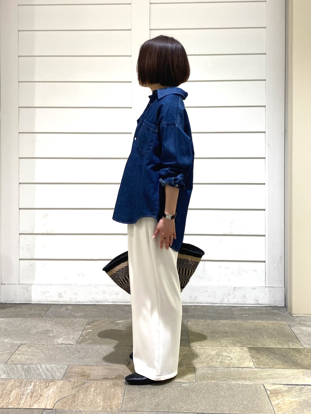 ブルー系のシャツ/ブラウス、ブラック系のかごバッグ、ホワイト系のその他パンツを着用したレディースの春コーディネートの4枚目の写真