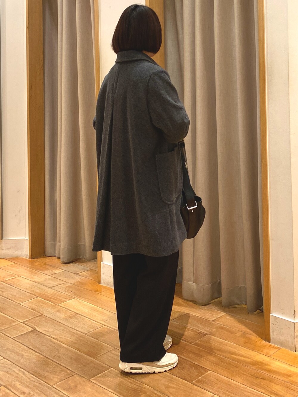 グレー系のダッフルコート、ホワイト系のTシャツ/カットソー、ブラック系のその他パンツを着用したレディースの冬コーディネートの6枚目の写真