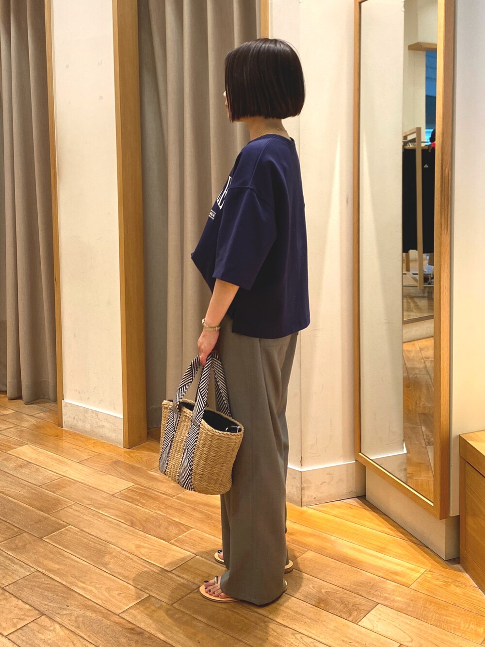 ブルー系のTシャツ/カットソー、ベージュ系のかごバッグ、グレー系のその他パンツを着用したレディースの春コーディネートの6枚目の写真