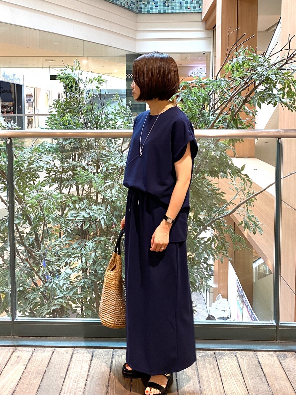 ブルー系のTシャツ/カットソー、ブルー系のスカート、ベージュ系のかごバッグを着用したレディースの夏コーディネートの3枚目の写真