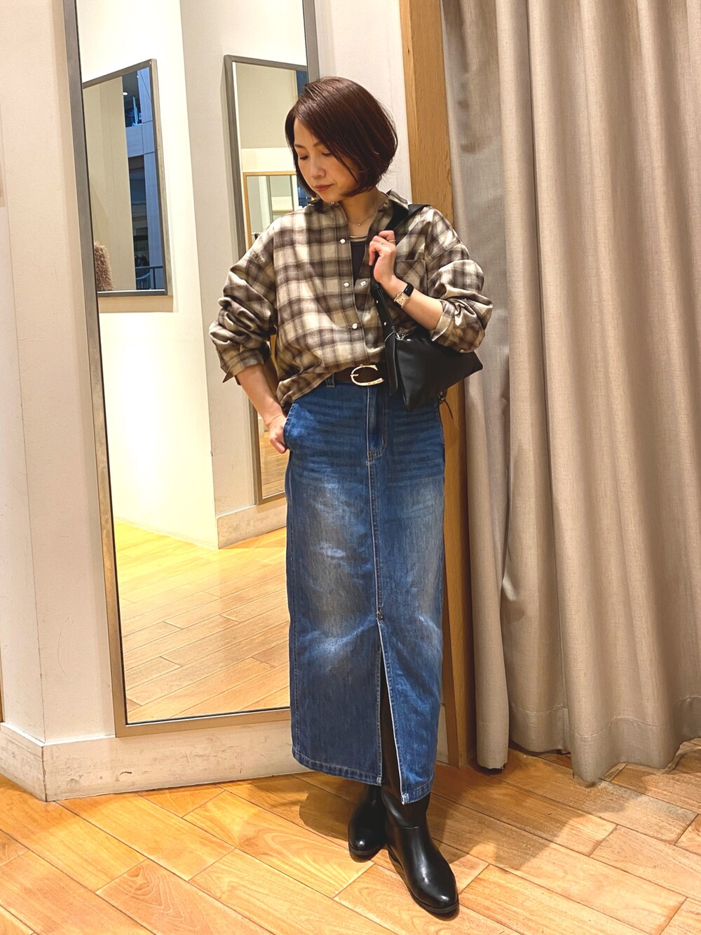 ブラウン系のシャツ/ブラウス、ブルー系のデニムスカート、ブラック系のショルダーバッグを着用したレディースの秋コーディネートの2枚目の写真