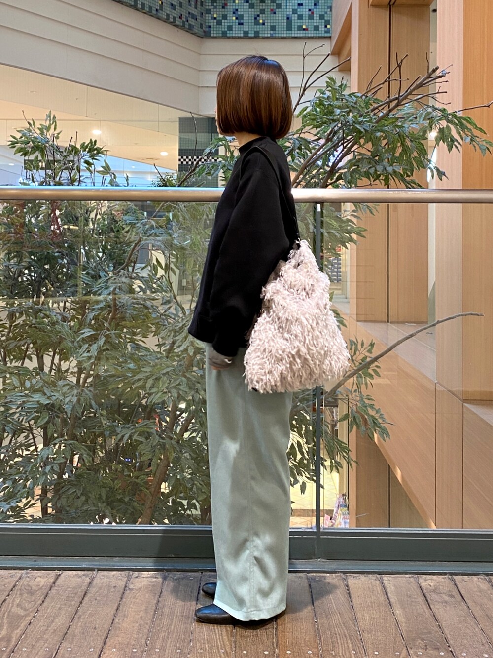 ブルー系のその他パンツ、グレー系のハンドバッグ、ブラック系のTシャツ/カットソーを着用したレディースの冬コーディネートの3枚目の写真