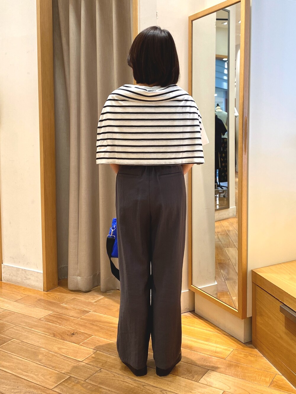 グレー系のスラックス、ブルー系のショルダーバッグ、ホワイト系のTシャツ/カットソーを着用したレディースの夏コーディネートの8枚目の写真