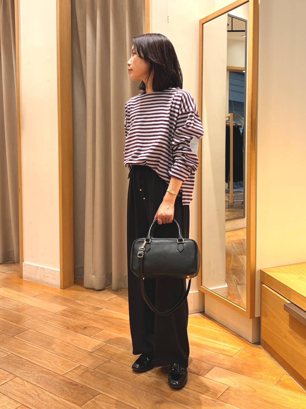 ブラック系のその他パンツ、ブルー系のTシャツ/カットソー、ブラック系のボストンバッグを着用したレディースの秋コーディネートの2枚目の写真