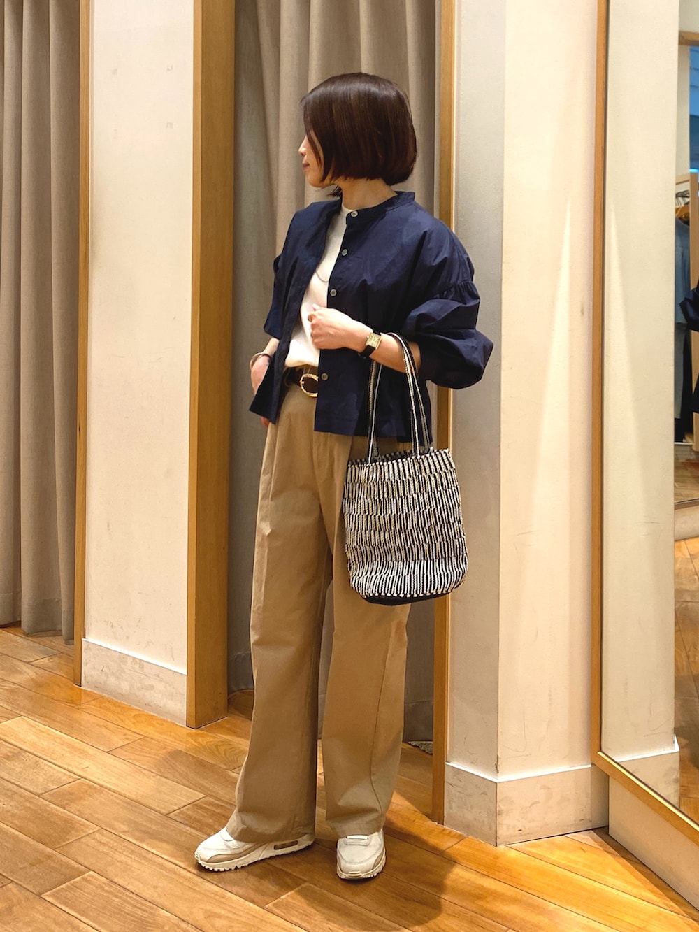 ベージュ系のチノパンツ、ブルー系のシャツ/ブラウス、ホワイト系のTシャツ/カットソーを着用したレディースの春コーディネートの2枚目の写真