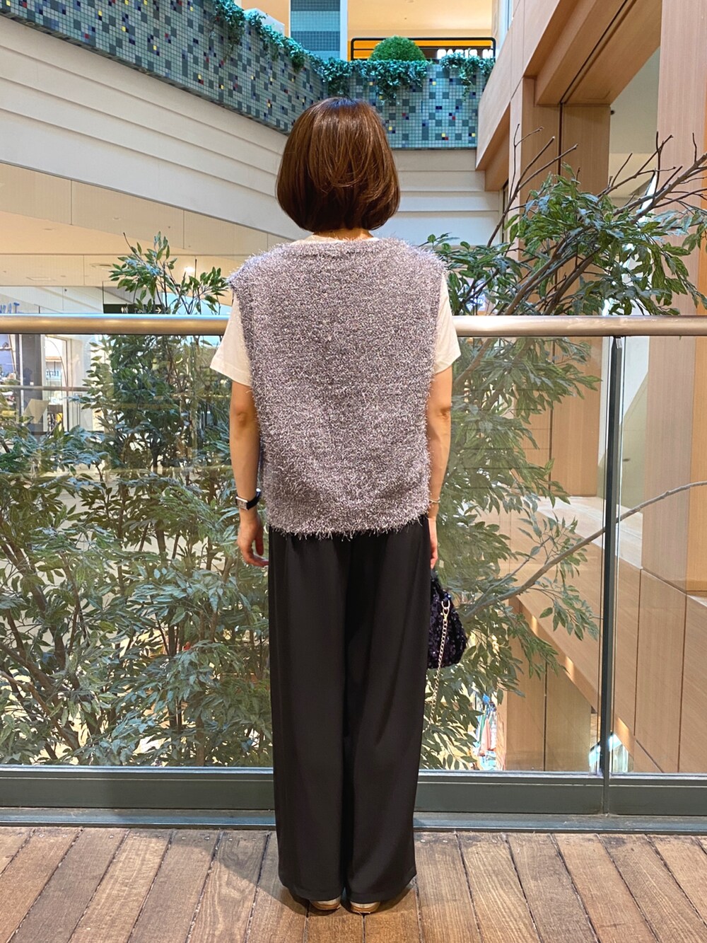 グレー系のベスト、ホワイト系のTシャツ/カットソー、ブラック系のその他パンツを着用したレディースの秋コーディネートの4枚目の写真