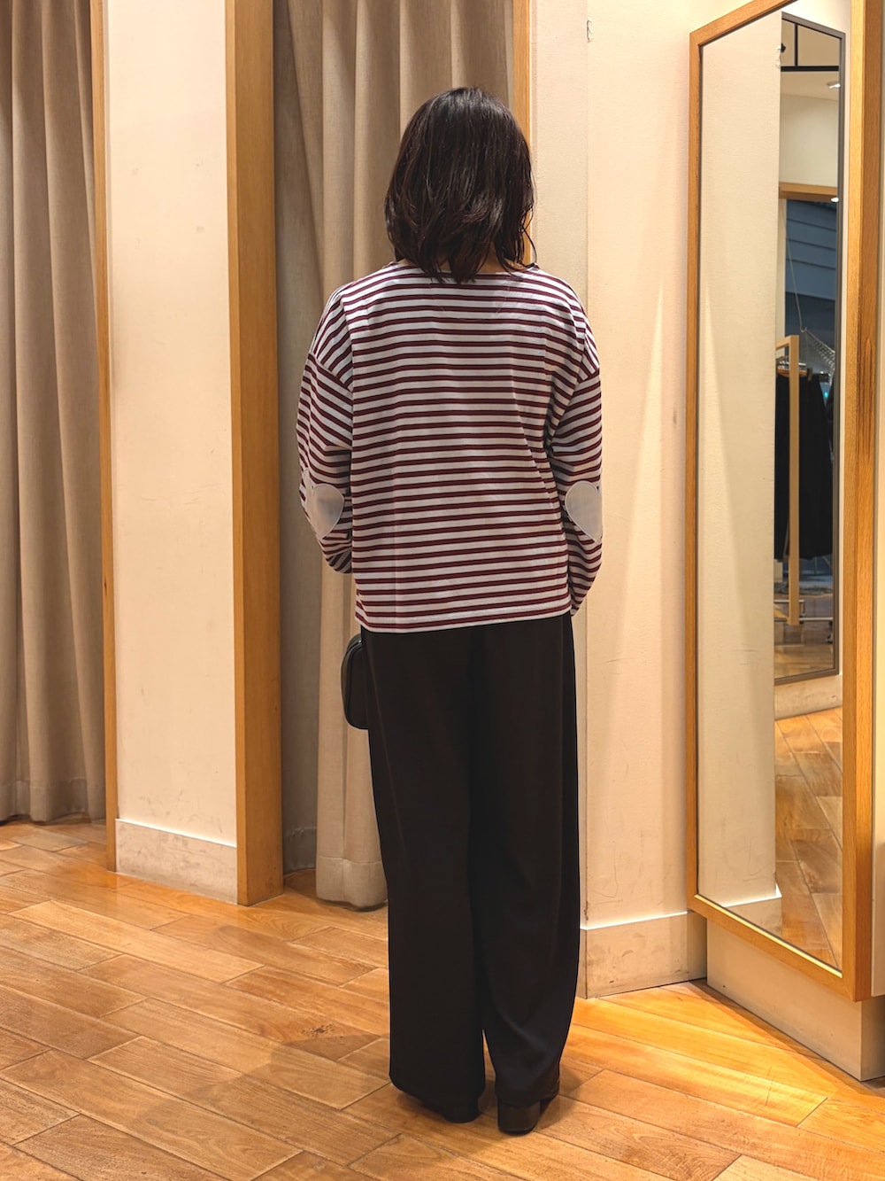 ブラック系のその他パンツ、ブルー系のTシャツ/カットソー、ブラック系のボストンバッグを着用したレディースの秋コーディネートの7枚目の写真