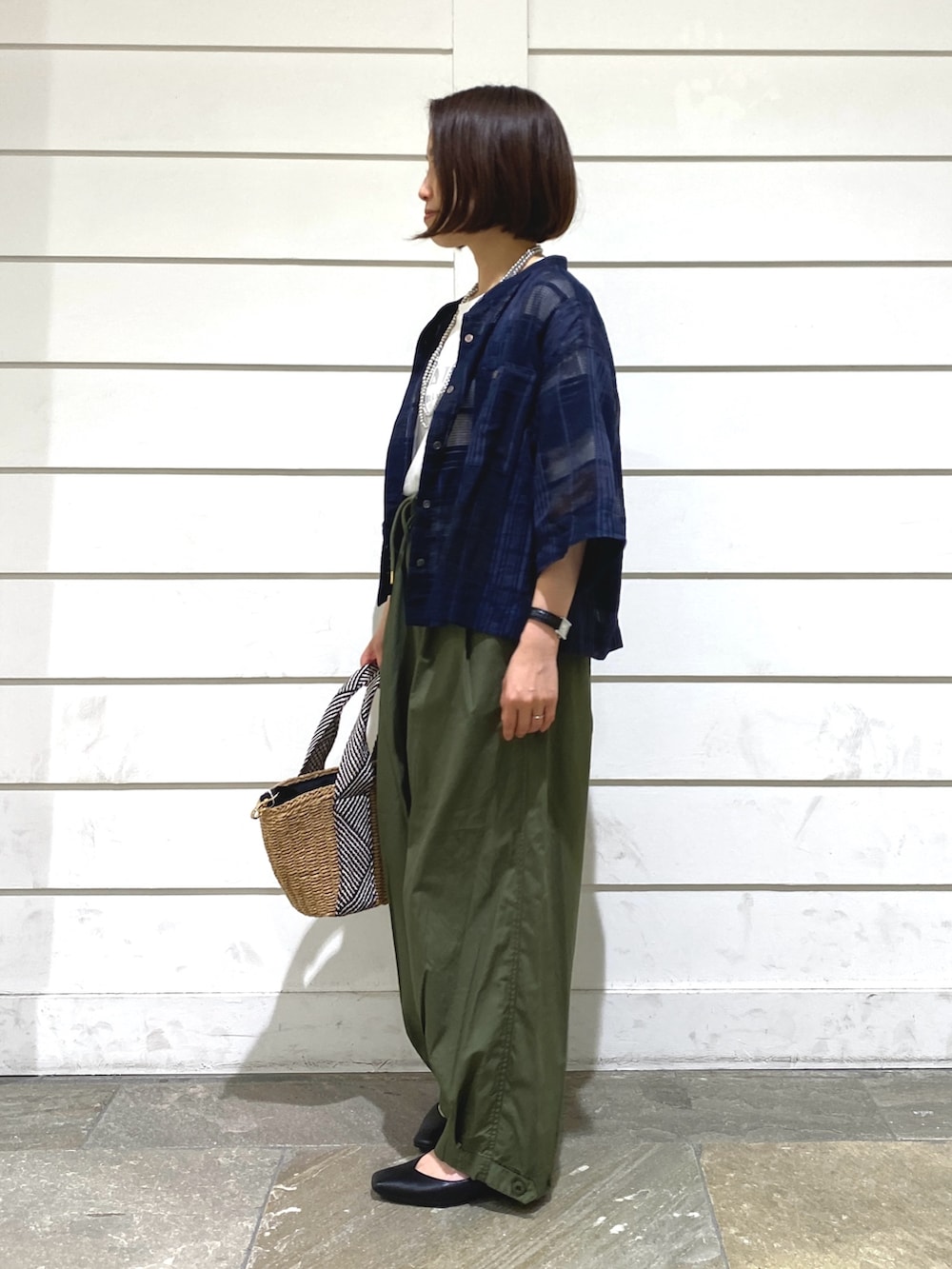 ブルー系のシャツ/ブラウス、グリーン系のその他パンツ、ベージュ系のかごバッグを着用したレディースの夏コーディネートの3枚目の写真