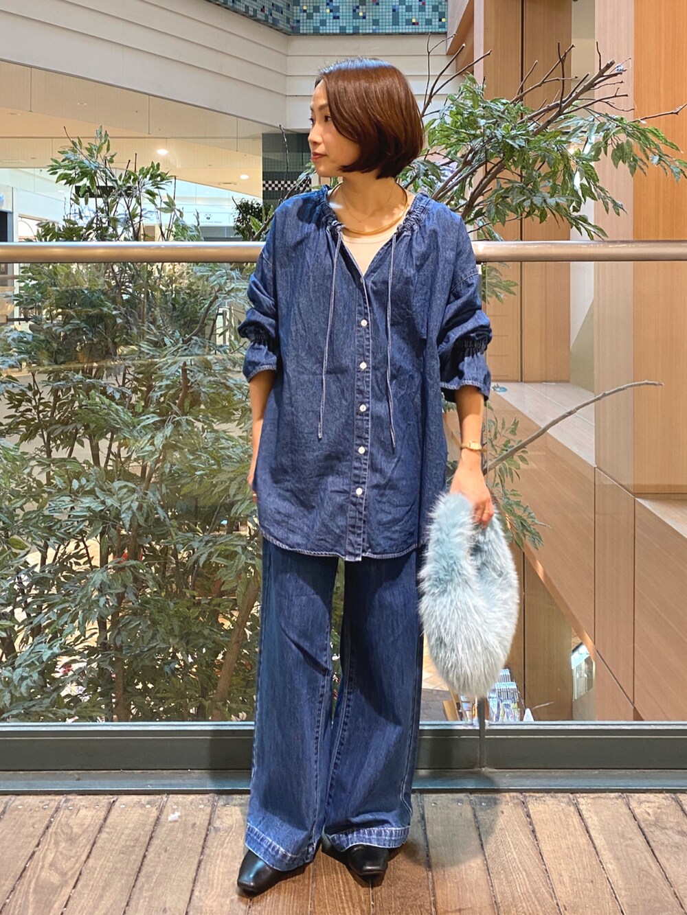 ブルー系のシャツ/ブラウス、ブルー系のデニムパンツ、ホワイト系のTシャツ/カットソーを着用したレディースの秋コーディネートの3枚目の写真