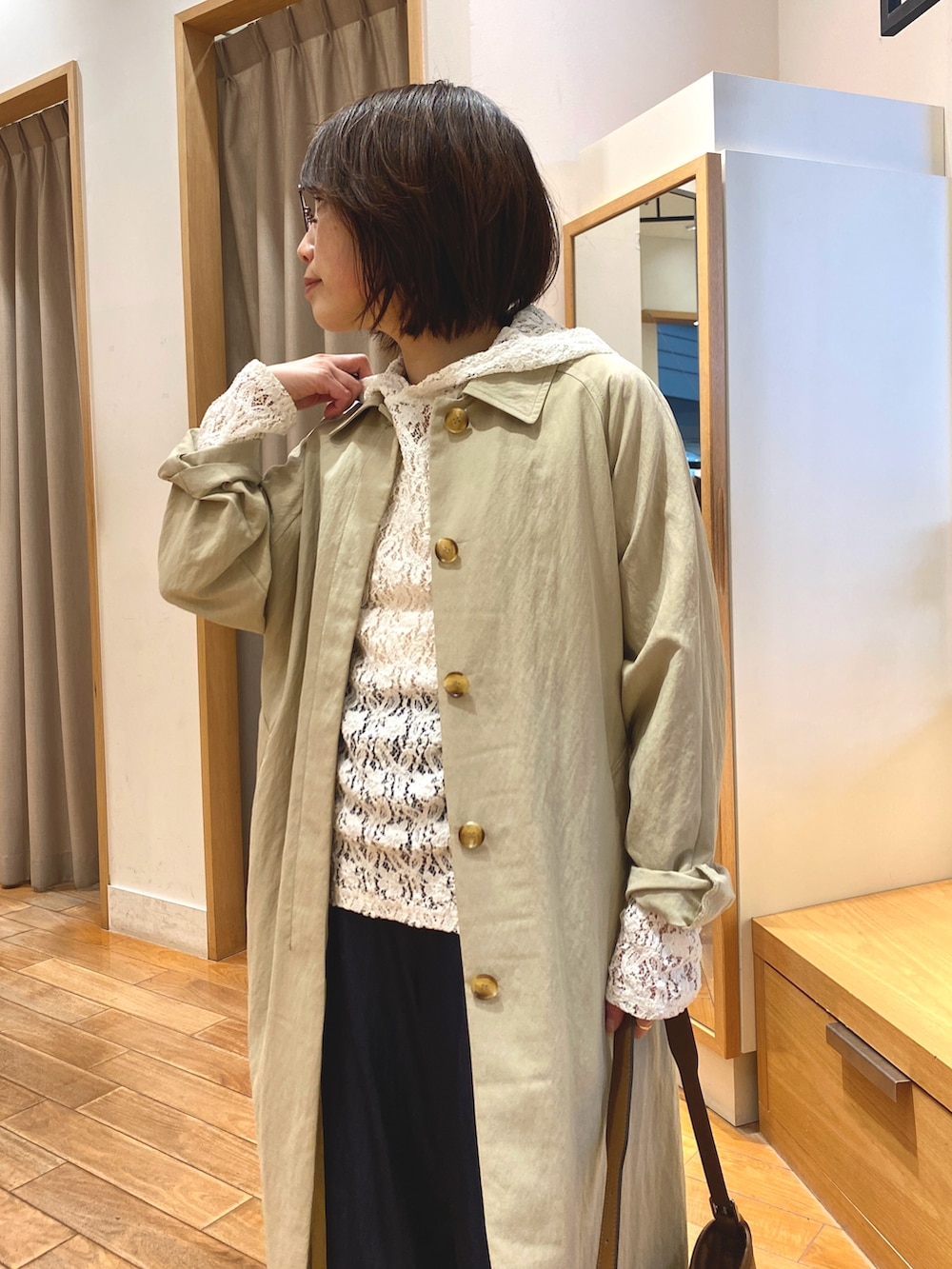 ホワイト系のTシャツ/カットソー、ベージュ系のステンカラーコート、ブラウン系のショルダーバッグを着用したレディースの春コーディネートの3枚目の写真